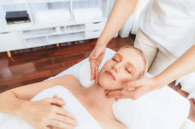 Kafkasyalı kadın stres önleyici kafa masajından ve lüks tatil beldesi ya da otel spa salonundaki modern ışık ortamında yüz güzelliği eğlencelerini şımartmaktan hoşlanıyor. Sessiz.