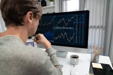 Bilgisayar ve dizüstü bilgisayarı kullanarak, çalışma masasındaki dinamik artırılmış borsa grafiğinin en yüksek kar değerini araştıran bir tüccar, modern ofisteki ekrandaki döviz kuru değerini analiz ediyor. Bireysel.