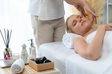 Kafkasyalı kadın stres önleyici kafa masajından ve lüks tatil beldesi ya da otel spa salonundaki modern ışık ortamında yüz güzelliği eğlencelerini şımartmaktan hoşlanıyor. Sessiz.