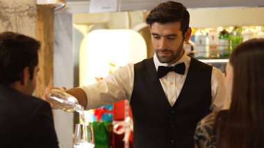 Zeki, gülümseyen barmen lüks bir barda buzlu içecekler hazırlarken aynı zamanda canlı, aydınlık atmosfer barında ve restoranda VIP müşterilerle canlı sohbetler yapıyor. Vinosity.