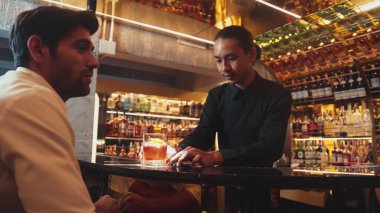 Barmen portakal kabuğu sıkar, cam kokteyl viskisinin üzerinden kokar, buz kalıbının tepesine eski moda kokar. Kulüpteki lüks gişe barında VIP müşteriye özel sunum yapar. Vinosity.