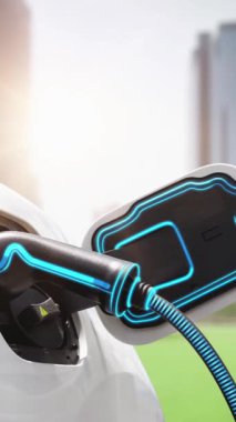 Yeşil Şehir Parkı 'ndaki ekolojik temiz enerji şarj istasyonundan gelen fütürist akıllı EV şarj aletinin şarj ettiği elektrikli araba. Alternatif enerji kullanan gelecekçi elektrikli araba. İnceleyin