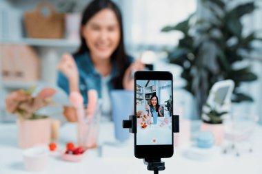 Genç ve güzel Asyalı bir kızın nemlendirici vücut kremi ürününü inceleyerek sosyal medyada koluyla en çok satanlar listesine giren canlı bir cilt testi yaptığı seçmeli bir odak telefonu. Taktik.