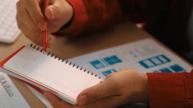 Mobil uygulama için kullanıcı arayüzü prototipi ya da masadaki program modeliyle birlikte web sitesi planlaması yapan bir şirket çalışanı. UX UI tasarımcısı kullanıcı dostu arayüz planını dikkate alır. Sinerjik