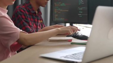 Yavaş çekim arkası yazılım geliştirici mühendisi bilgisayar programlama için birlikte çalışarak hata ayıklama kodunu çözüyor, ofiste monitörde karmaşık algoritmaları çözüyor. Filizlenen