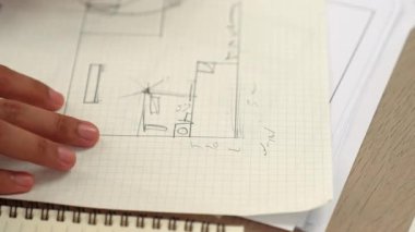 Ölçüm ve yazma aracını kullanarak mimari ofisindeki inşaat doğruluğu için ayrıntılı bir plan tasarlayan akıllı mimar ya da akıllı mühendisin videosu. Eline odaklan. - Yakın çekim. Tanımlama.