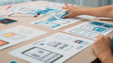 Mobil uygulama için kullanıcı arayüzü prototipi ya da masadaki program modeliyle birlikte web sitesi planlaması yapan bir şirket çalışanı. UX UI tasarımcısı kullanıcı dostu arayüz planını dikkate alır. Sinerjik