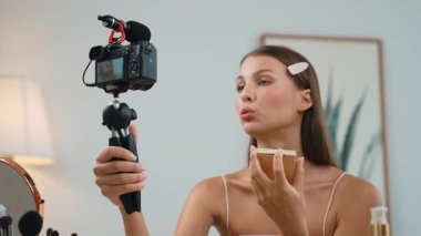 Sosyal medya için güzellik ve kozmetik video içeriği hazırlayan genç bir kadın. Güzellik blogcusu kameraya gülümserken seyircilere ve takipçilere güzellik bakımını gösteriyor. Düzenle