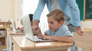 Çeşitli öğrenciler yapay zeka yazılımı kullanırken, Kafkas öğretmeni enerjik çocuğa kodlama konusunda yardım ediyor. Çocuklar oturma ve programlama sistemi. Sevimli bir öğrenci şifreyi öğreniyor. Pedagoji.