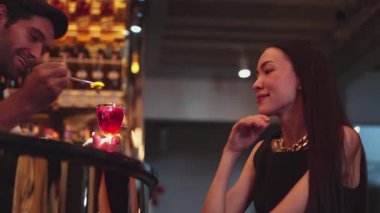 Barmen lüks tezgah barında güzel misafirler için çiçeklerle süslenmiş karışık votka kokteyli servis ediyor. Mükemmel canlı renk sunumu. Atmosfer gece kulübünü ön plana çıkarıyor. Vinosity.