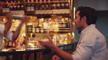 Eski usulde gülümseyen akıllı adam kokteyl içerken, barmen de özel içkiler hazırlıyor. Cuma gecesi lüks bir gişede, gece kulübünde, canlı bir içecekle servis yapmak için sallanıyor. Vinosity.