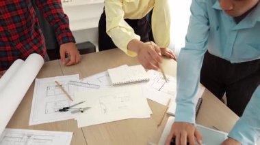 Mimarlık ve güvenlik mühendisi, modern ofiste doğruluk için mimari belge ve ölçüm aracı kullanılarak dizüstü bilgisayarın üzerinde sergilenen planlar hakkında tartıştı. - Yakın çekim. Tanımlama.