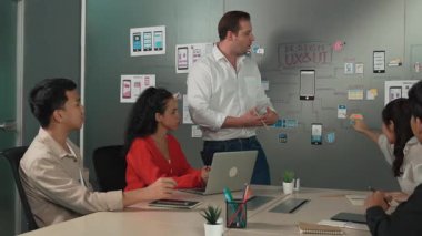 Bir grup profesyonel iş adamı Ux ve Ui tasarımı hakkında konuşuyor. İşbirlikçi çeşitli iş adamları pazarlama planı hakkında beyin fırtınası yapıyor. Birlikte çalışan iş adamları. Yönlendirici.
