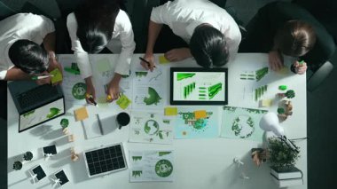 Yönetici yöneticisinin üst görünümü toplantılarda tablet temiz enerji gösterir. İş adamlarının sürdürülebilir çevre yatırımlarını planlamak ve yatırım yapmak için birlikte çalıştıklarına dair havadan bir bakış açısı. Hizalama.
