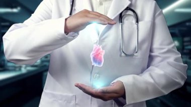 Hastanede kalp anatomisi hologramını tutan profesyonel doktorlara yakın çekim. Teknoloji yeniliklerini kullanarak kalp ameliyatına hazırlanan zeki bir tıp çalışanı. Kardiyoloji. İyileştirici.