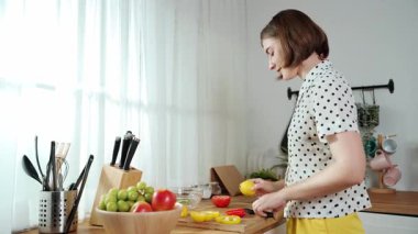 Çekici beyaz anne salata yapmak için taze sebze doğruyor. Mutlu enerjik akıllı anne kahvaltıda sağlıklı yemek pişirirken modern mutfakta çalışıyor. Yemek hazırlama konsepti. Pedagoji.