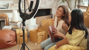 İnternette yayınlanırken gitar kılıfını gösteren ve satan mutlu bir çift. Çekici kız oturma odasında reklam ürünleri için online pazarlama kullanarak yayın yapıyor. Myrmidon.