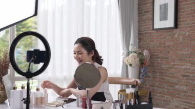 Kadın nüfuzlu kişi sosyal medya ya da blog için canlı yayın yapan video klip eleştirmeni derisini çekiyor. Canlı kozmetik stüdyosu ışıklandırması olan mutlu genç bir kız pazarlama için internet üzerinden yayın yapıyor..