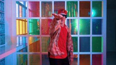 Serbest stil tişört giyerken sokak müziği çalan mutlu hipster. Gece kulübünde neon ışıkla dururken çekici break dansçı dans ve hareketli hareketler yapıyor. Mutluluk.