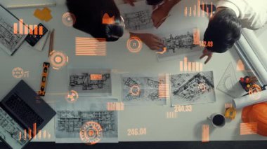 Kaliteli mimar mühendis ekibinin ev tasarlamak için birlikte çalışmasına tepeden aşağı bir bakış açısı. Proje yöneticisinin hava görüntüsü inşaatı finansal ve istatistiksel olarak gösteriyor ve açıklıyor. Hizalama.