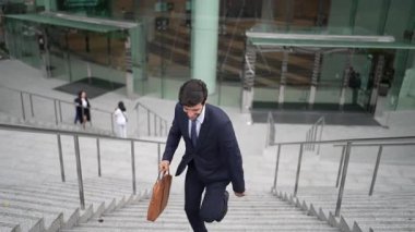 Terfi alma, satışları artırma, maaşları artırma konusunda iyi haberleri kutlamak için dans eden mutlu iş adamı şehirde geçmişi bulanık bir şekilde merdivenlerden çıkarken. Neşeli bir ruh hali. Sevinçli..