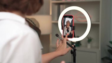 Arka plan etkileyicisi, vlog video gözden geçirme makyaj primi sosyal medya ya da blog kullanarak akıllı telefon yayınıyla canlı çekim yapıyor. İnternetteki pazarlama kaydı için kozmetik stüdyosu ışıklandırması olan kız.
