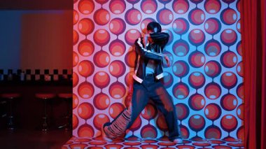 Asyalı break dansçı serbest stile geçiyor ve balon arka planlı kameraya bakıyor. Profesyonel hippi gündelik kıyafet giyer ve gözlük takar. Mutluluk.