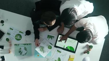 Yenilenebilir enerji hakkında tartışan iş ekibinin aşağı görüşü. Masada dizüstü bilgisayar kullanırken sıfır atık hakkında plan yapmak için birlikte çalışan yetenekli iş adamlarının hava görüşü. Hizalama.