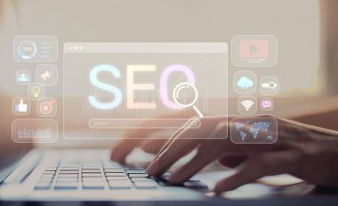 İnteraktif SEO arayüzü içeren bir dizüstü bilgisayarda çalışan ellerin yakın plan görüntüsü. Bu görsel çizimler arama motoru optimizasyonu, analitik ve çevrimiçi pazarlama stratejisi kavramlarını göstermektedir. XDMCP