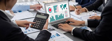 İş zekası ve veri analizi kavramı. Analizci ekibi laptop ekranında finansal veri analizi üzerinde çalışıyor. Etkili iş stratejik planlama için pazarlama göstergesi olarak. İçgörü