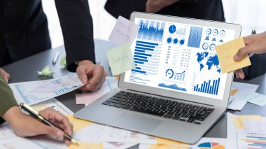 Analizci ekibi yaratıcı ve analitik beyin fırtınası fikri için bilgisayar ekranında BI veri paneli olan yapışkan bir not kullanıyor. Pazarlama stratejisi için finansal veri görselleştirme teknolojisini analiz et. Dahi.