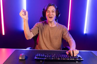 Kazanmak için çevrimiçi oyun oynayan akıllı flama makinesinin sunucu kanalı, neon ışıklı odada seçilen takım yarışması için izleyicilerle birlikte canlı yayında canlı yayında kulaklık takıyor. Bireysel.