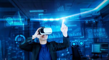 VR gözlüklü bir proje yöneticisi mali tabloyu ve ofisteki parlak mavi ışığı gösteriyor. Yetenekli iş adamı artırılmış gerçeklikten elde edilen verileri kullanarak pazarlama stratejisini kontrol edip planlıyor. Yaratıcılık.