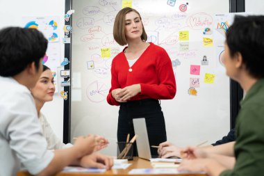 Profesyonel çekici kadın lider, modern iş toplantı odasında beyin fırtınası zihin haritalama istatistikleri ve renkli yapışkan notlar kullanarak yaratıcı pazarlama planını sunuyor. Tertemiz..