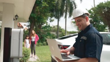 Evde EV şarj istasyonu kurulumu üzerinde çalışan nitelikli teknisyen, EV için dizüstü bilgisayarla şarj sisteminde sorun çıkarma ve yapılandırma ayarları yapıyor. Titiz