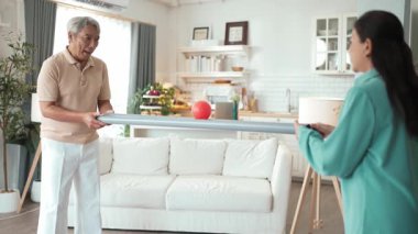 Yaşlı bir adam evde partneriyle top yuvarlama oyunu oynuyor, zihinsel ve fiziksel sağIık için el-göz koordinasyonu, odaklanma ve motor becerileri pratiği yapıyor. Sağlık hizmetleri konseptini engelliyor. Myrmidon.