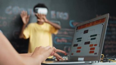 VR kullanan Afrikalı öğrenci meta-dünya ile etkileşime girerken liseli kız el kodlama programını kapat. Zeki çocuk sanal gerçeklik gözlüğü takıyor ve yenilikçi sınıfta video oyunları oynuyor. Öğretim