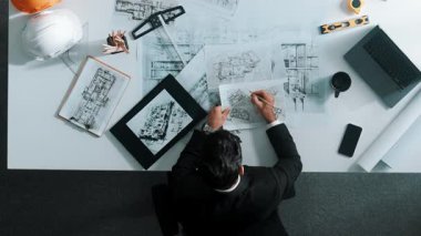 Tablet, dizüstü bilgisayar, güvenlik kaskı ve ekipmanlarla toplantı masasında otururken ev tasarımı için malzeme seçen yetenekli mühendis görüşü. Akıllı mimar proje planına bakıyor. Hizalama.