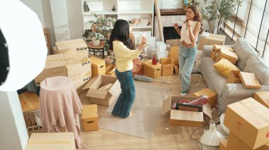 Taşınırken oturma odasında mutlu lezbiyen aşıklar dans ediyor. Birkaç arkadaş müzik eşliğinde salonda karton kutularla dans ederek serbest dans ediyorlar. Yeniden yerleştirme. Myrmidon.