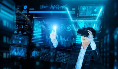 Finansal verileri analiz ederken veri merkezinde duran kulaklıklı bir iş adamı. Yönetici, pazarlama istatistiksel hologramını işaret ediyor ve karar verirken artırılmış gerçeklik gözlükleri kullanıyor. Yaratıcılık.