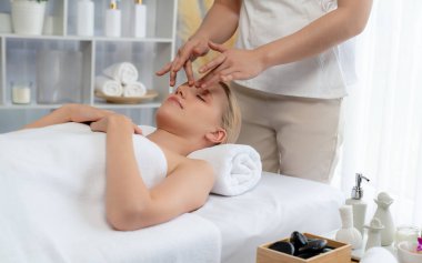 Kafkasyalı kadın stres önleyici kafa masajından ve lüks tatil beldesi ya da otel spa salonundaki modern ışık ortamında yüz güzelliği eğlencelerini şımartmaktan hoşlanıyor. Sessiz.