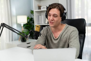 Sunucu kanalı, gülümseyen akıllı yayıncı kaydı, senaryosu ve akıllı telefonuyla sosyal medyada sohbet programı, kulaklık takarak modern ev stüdyosundaki video flamalarını kaydediyor. Bireysel.