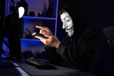 Beyaz gülümseyen isimsiz suçlu maskesi kurbana sesleniyor, kişisel bilgileri hacklemeye ikna ediyor, veri sunucu sistemindeki bilgisayar korsanlarının kullandığı şifreleme programını paylaşıyor. Tahmin et..