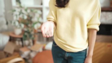 Anahtarı elinde tutan genç girişimci, merkez büroda dikilirken. Küçük işletmeleri yönetmek ya da başlamak için anahtarı taşırken kameraya özgüvenle bakan mutlu kadın satıcı. Myrmidon.