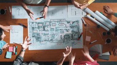 Proje planı, mimari teçhizat, plan ve renk paletleriyle toplantı masasında dururken inşaat yapmaktan bahseden yetenekli inşaat mühendisinin havadan aşağı bakış açısı. Sempozyum.