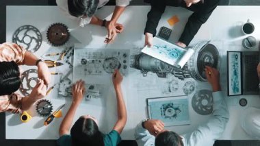 Türbin motoru tasarlamak için çalışan akıllı mühendis takımının yukarıdan aşağıya hava görüntüsü. Profesyonel teknisyen jet motoru yapımını tartışırken motorun bir kısmını işaret ediyor. Hizalama.