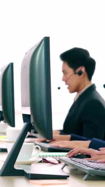 Ofiste çalışan kulaklık takan işadamları uzak müşteri ya da meslektaşlarını desteklemek için çalışıyorlar. Arama merkezi, tele pazarlama, müşteri destek acentesi telefon görüşmesinde hizmet sunar.