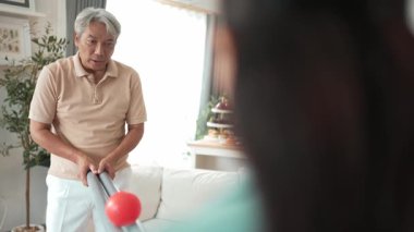 Yaşlı bir adam evde partneriyle top yuvarlama oyunu oynuyor, zihinsel ve fiziksel sağIık için el-göz koordinasyonu, odaklanma ve motor becerileri pratiği yapıyor. Sağlık hizmetleri konseptini engelliyor. Myrmidon.
