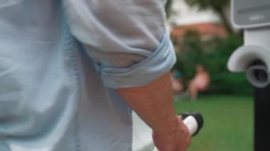 Mutlu ve neşeli bir ailenin arka planında ev şarj istasyonundan elektrikli araç şarj ediliyor. EV arabası daha iyi bir gelecek için alternatif ve sürdürülebilir enerji kullanıyor.