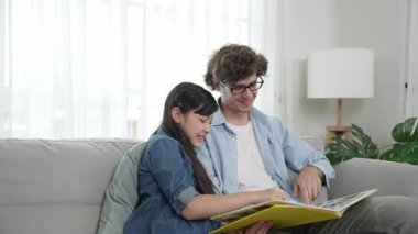 Beyaz bir baba ve tatlı bir kız kanepede otururken masal kitabı okuyorlar. Mutlu bir baba, sevimli bir Amerikan çocuğuna, birlikte zaman geçirirken hayal gücünün gelişmesi için hikaye anlatıyor. Pedagoji.